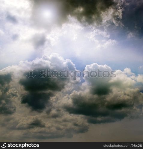 Overcast sky and the sun behind cumulus clouds.