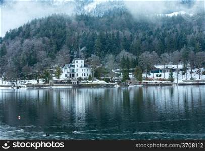 Overcast winter Alpine lake Grundlsee view with white house (Austria)