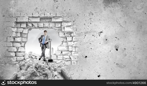 Overcoming challenges. Determined businessman with big hammer in hands