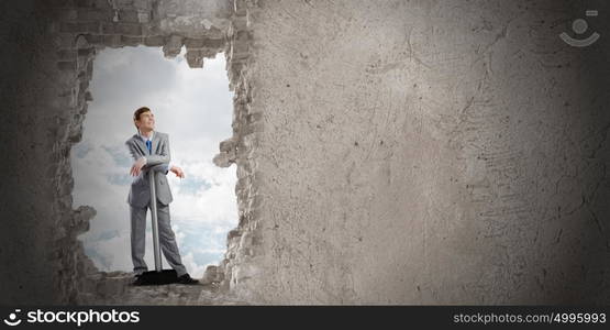 Overcoming challenges. Determined businessman with big hammer in hands