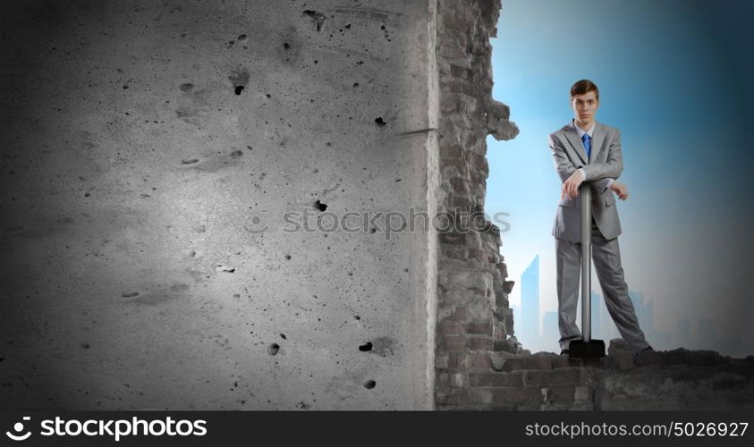 Overcoming challenges. Determined businessman with big hammer in hands