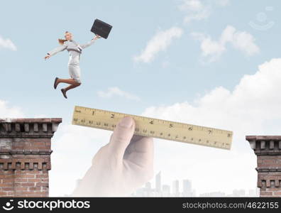 Overcoming difficulties. Businesswoman jumping over gap. Risk and challenge concept