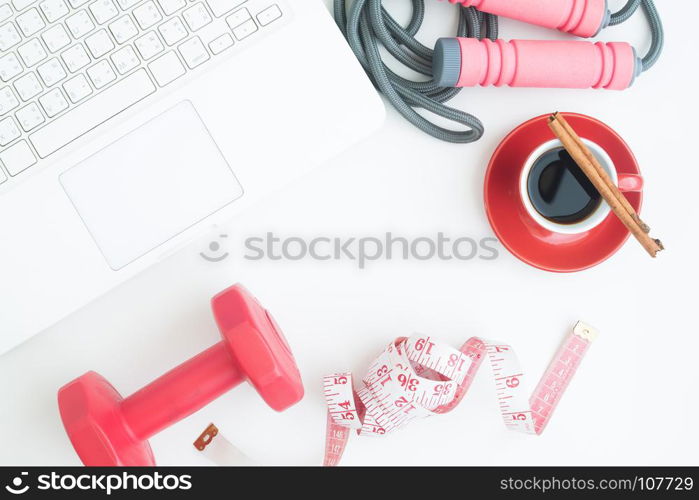 Overgead view of workspace with laptop, cup of coffee and sport equipments on white