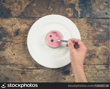 Overhead shot of a male hand scooping yogurt with a spoon