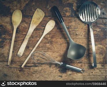 Overhead shot of a selection of spoons and other kitchen utensils on a wooden table