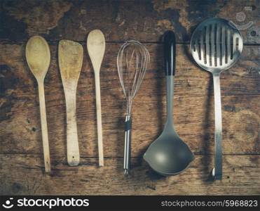 Overhead shot of a selection of spoons and other kitchen utensils on a wooden table