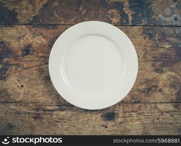 Overhead shot of a white plate on a wooden table