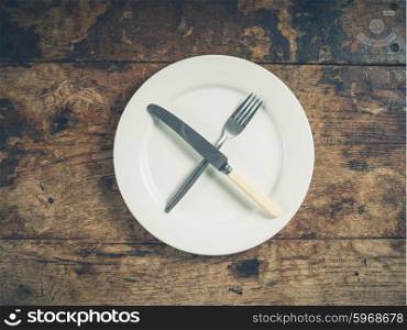 Overhead shot of a white plate with a knife and fork