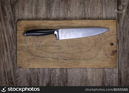 Overhead shot of bread board and nice and clean knife with space for text, menu or design
