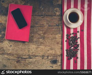 Overhead shot of coffee concept with cup, tea towel, a book and a smart phone