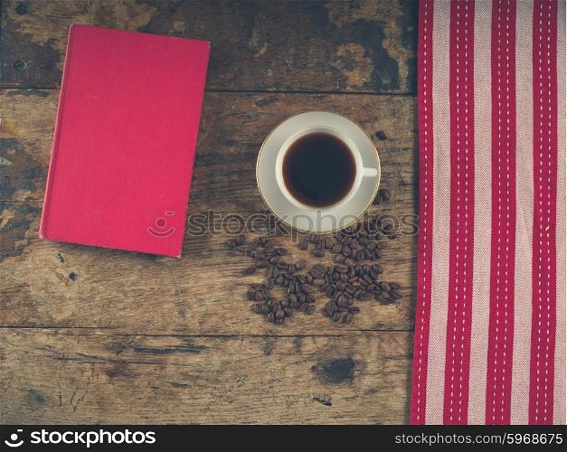 Overhead shot of coffee concept with cup, tea towel, a book and beans