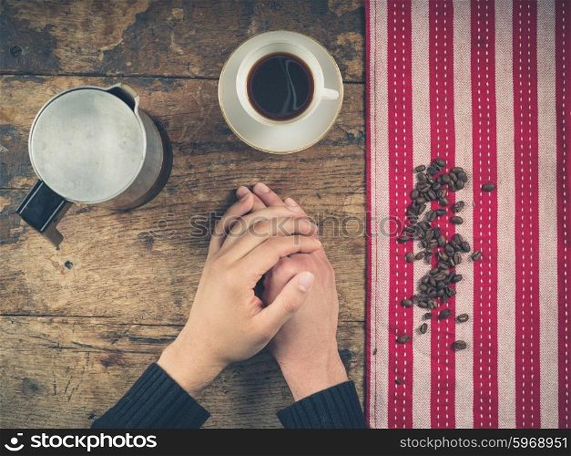 Overhead shot of coffee concept with cup, tea towel and a person&rsquo;s hands