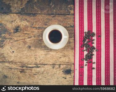 Overhead shot of coffee concept with cup, tea towel and beans