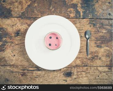 Overhead shot of pink yogurt on a plate with a spoon