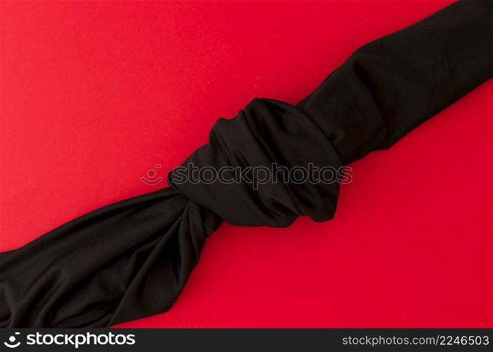 overhead view black knot fabric red background