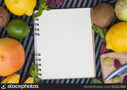 overhead view blank white spiral notepad with various fresh fruits