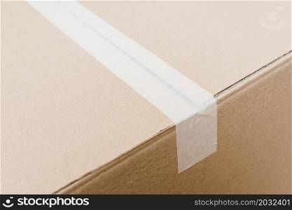 overhead view cardboard box sealed with white packing tape