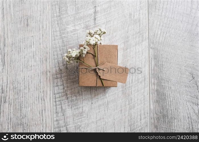 overhead view cardboard box tied with tag baby s breath flowers wooden desk