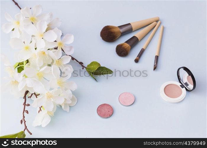 overhead view cherry blossom makeup brush blusher colored background