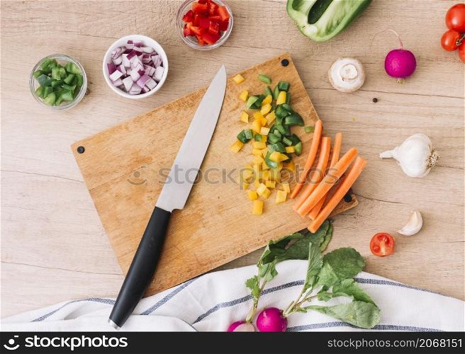 overhead view chopping board with knife vegetables wooden desk