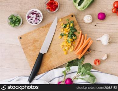 overhead view chopping board with knife vegetables wooden desk