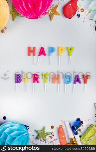 overhead view colorful happy birthday candles with party items white backdrop