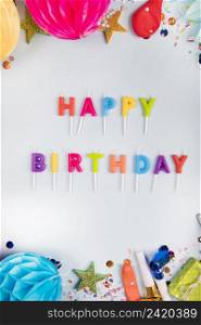 overhead view colorful happy birthday candles with party items white backdrop