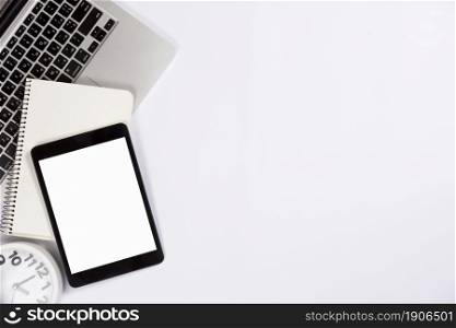 overhead view digital tablet notepad laptop with alarm clock isolated white background. High resolution photo. overhead view digital tablet notepad laptop with alarm clock isolated white background. High quality photo