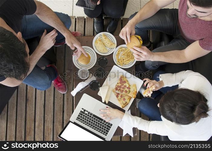 overhead view female using laptop with his friends enjoying snack restaurant