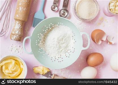 overhead view flour eggs butter equipments pink background. High resolution photo. overhead view flour eggs butter equipments pink background. High quality photo