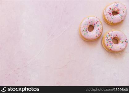 overhead view fresh donuts with sprinkles pink backdrop. Resolution and high quality beautiful photo. overhead view fresh donuts with sprinkles pink backdrop. High quality beautiful photo concept