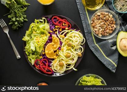 overhead view garnished healthy salad plate with drifts fork against black background