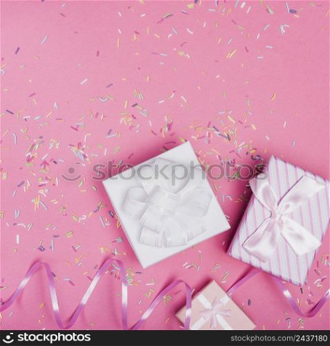 overhead view gift boxes with curl ribbon sprinkle pink background