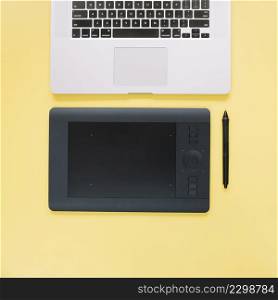 overhead view graphic digital tablet laptop yellow surface