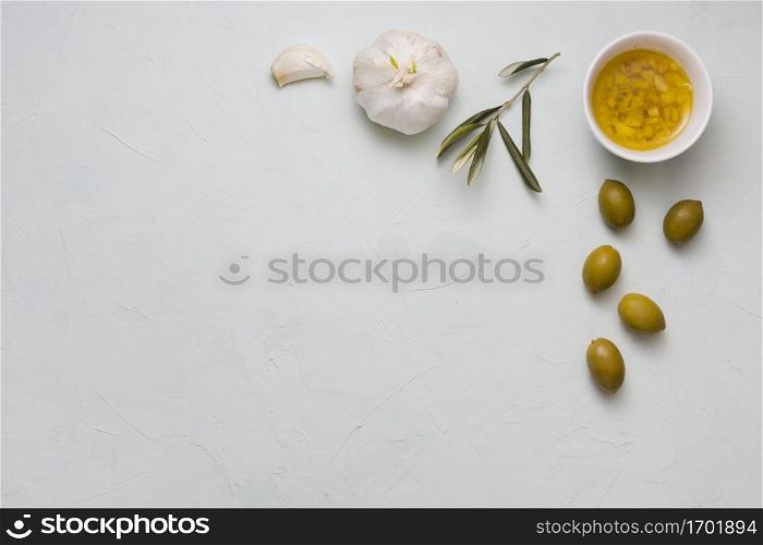 overhead view infused olive oil garlic bowl concrete backdrop