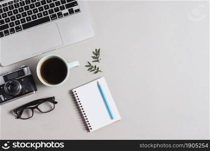 overhead view laptop vintage camera eyeglasses tea cup colored pencil notepad against white backdrop. Beautiful photo. overhead view laptop vintage camera eyeglasses tea cup colored pencil notepad against white backdrop
