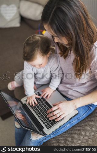 overhead view mother sitting with her child using laptop