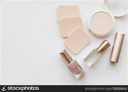 overhead view nail polish bottle lipstick sponge compact white background. Resolution and high quality beautiful photo. overhead view nail polish bottle lipstick sponge compact white background. High quality beautiful photo concept