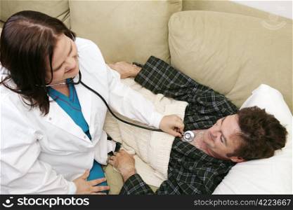 Overhead view of a home health nurse using stethoscope to listen to her patient&rsquo;s heart. Room for text.