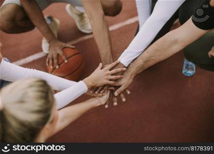 Overhead view of basketball team holding hands over court