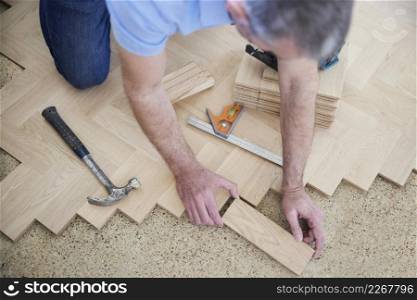 Overhead View Of Carpenter Or Builder Laying New Wood Block Parquet Parquet Floor In Kitchen At Home