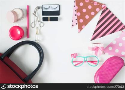 Overhead view of essential beauty items, Top view of party accessories, red hand bag, fashion eyeglasses and cosmetics, top view isolated on white background