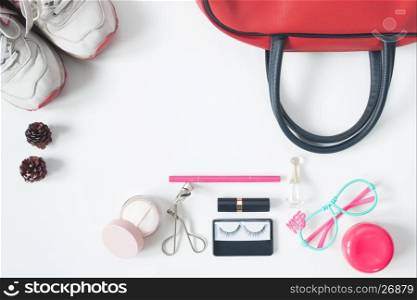Overhead view of essential beauty items, Top view of red hand bag, fashion eyeglasses, cosmetics and sneakers, top view isolated on white background