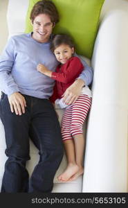 Overhead View Of Father And Daughter Relaxing On Sofa