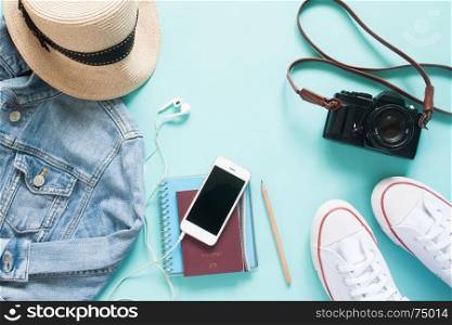 Overhead view of mobile device with passport and female items for vacation, travel lifestyle concept