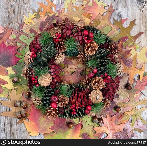 Overhead view of seasonal autumn wreath and leaves on rustic wood