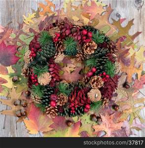 Overhead view of seasonal autumn wreath and leaves on rustic wood