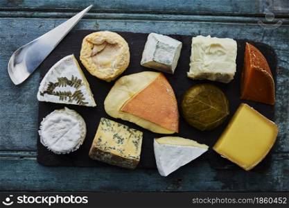 Overhead View Of Selection Of Luxury Cheeses On Slate Board With Knife