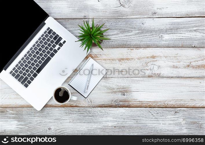 Overhead view of working desktop and writing stationery, coffee and baby plant with plenty of copy space