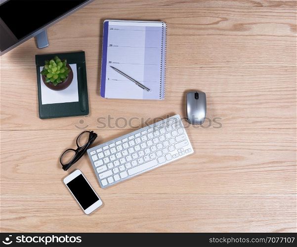 Overhead view of working office oak desktop with basic work items